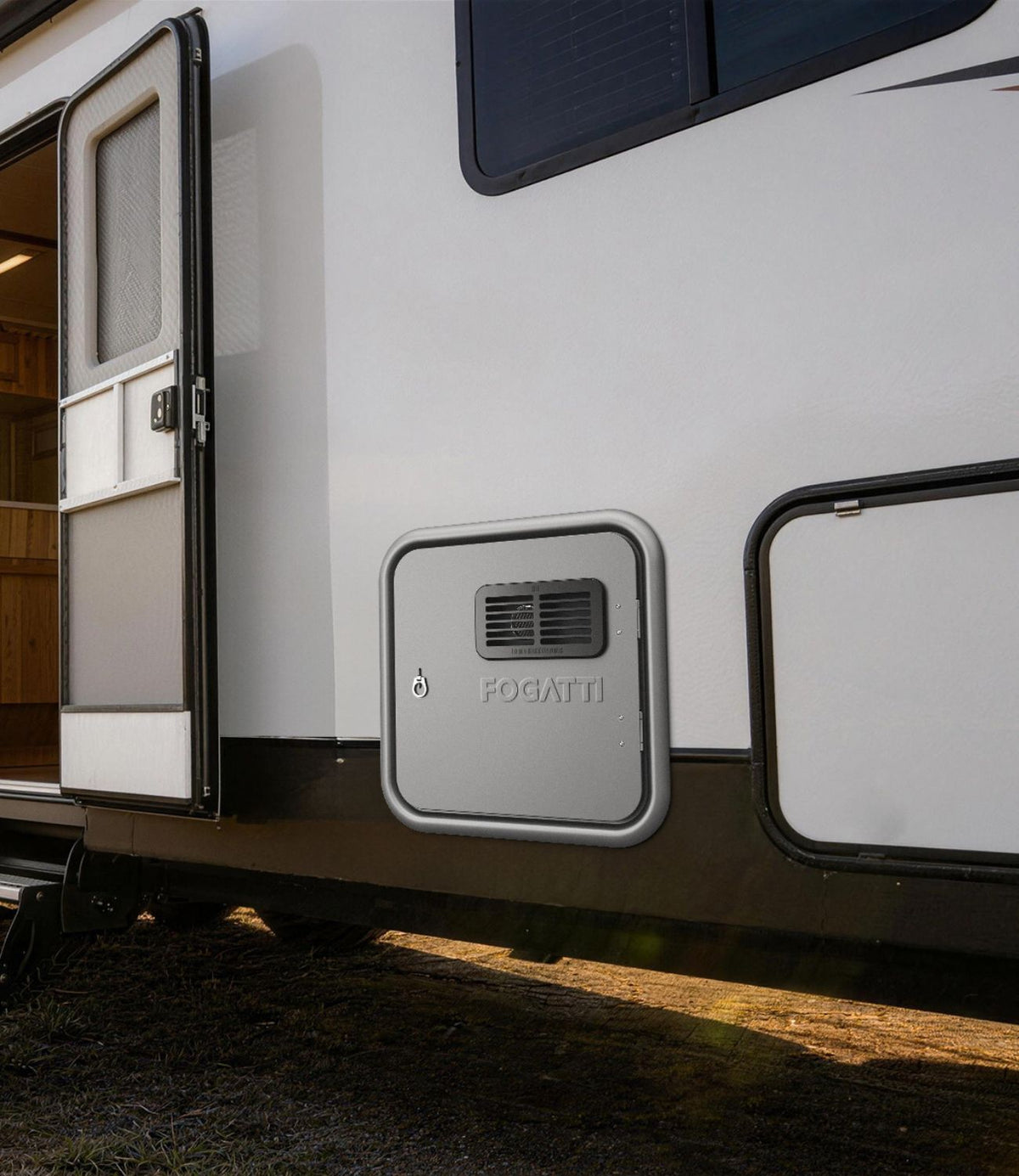 Brand new Fogatti Instashower RV Tankless Water Heater door with lock, installed on the side of a travel trailer for easy access.