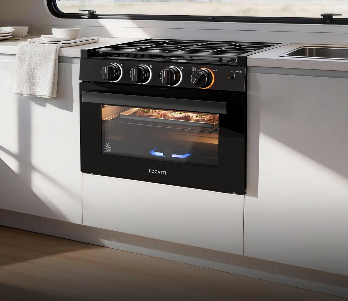 Fogatti black RV stove and oven with backlit knobs baking food