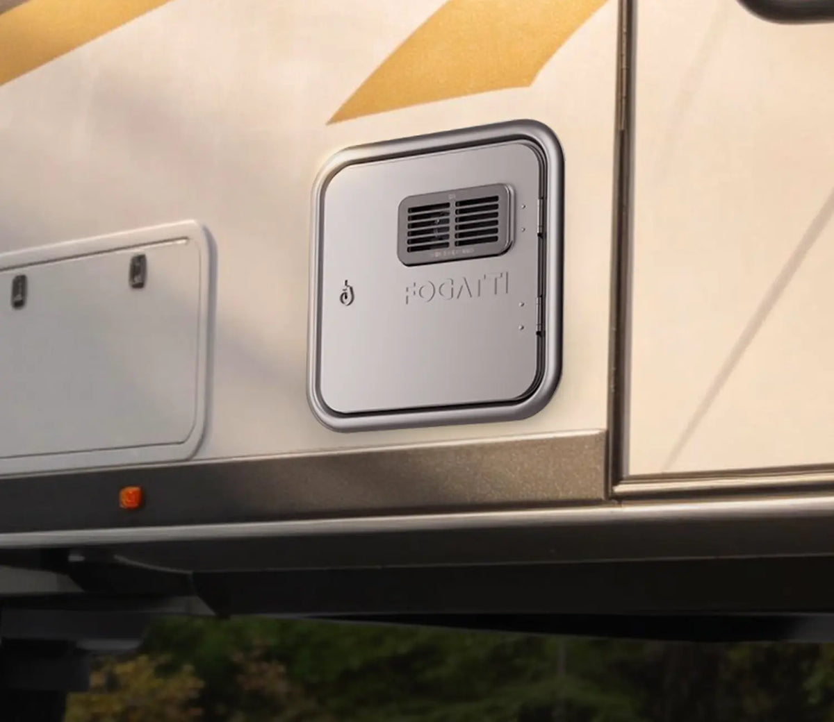 Close-up of a Fogatti water heater mounted on the side of an RV, showcasing its design and installation features.